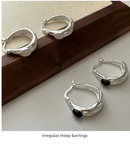 Detailed view of irregular 925 silver hoop earrings with black and white agate stones