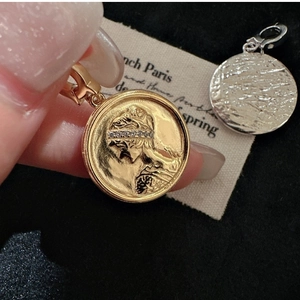 Detailed view of gold and silver S925 sterling silver coin pendants with relief portraits