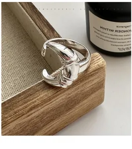 Detailed close-up of S925 sterling silver moon ring with smooth knotted design texture