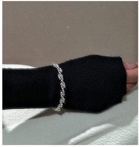 Close-up of S925 sterling silver beaded twisted rope bracelet on a black knit sleeve