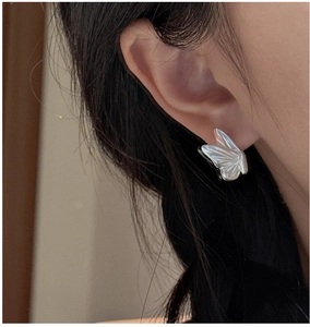 Side view of S925 sterling silver butterfly earrings with matte textured wings on model