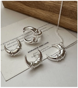 Detailed close-up of S925 silver crescent moon necklace and ring set with rope texture