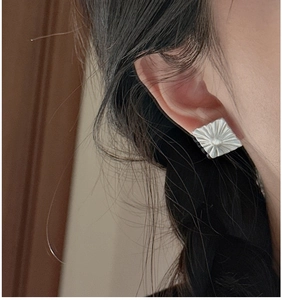 Macro shot of S925 sterling silver square stud earrings with unique pleated metal texture