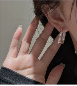 Close-up of minimalist S925 sterling silver rectangular hoop earrings worn by a model
