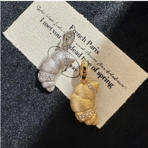 Detail of croissant-shaped S925 silver pendants in gold and silver matte finishes