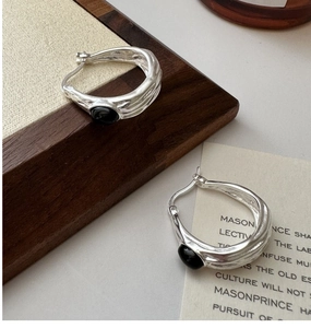 Detail shot of vintage 925 silver hoop earrings with irregular lava texture and black onyx