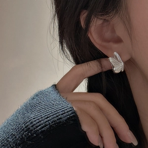 S925 sterling silver butterfly stud earring with matte finish worn by a model