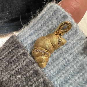 Golden croissant pendant with matte finish and fine micro-inlaid zircons on blue fabric