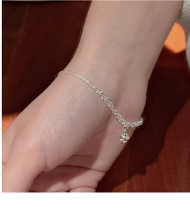 Gros plan d'un bracelet minimaliste en argent 925 avec pendentif boule et chaîne mixée