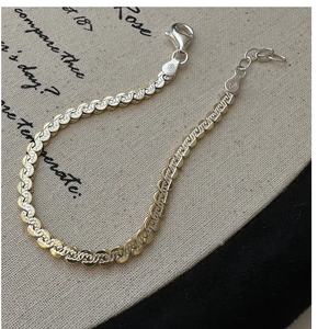 Macro shot of S925 sterling silver two-tone braided chain with lobster clasp and textured links