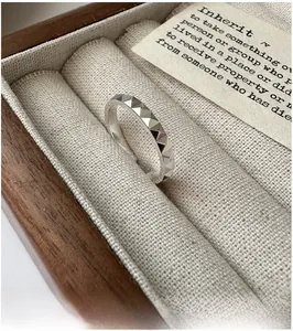 Macro shot of S925 sterling silver ring with geometric pyramid texture in a wooden box