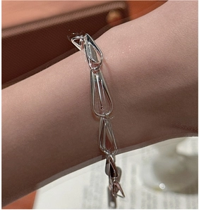 Detail of silver S925 sterling silver bracelet with hollow teardrop links on wrist