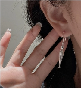 Macro detail of elegant silver teardrop drop earrings on a model for a stylish look