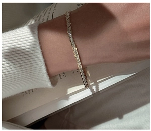 Close-up of S925 sterling silver gourd chain bracelet worn with a white knitted sweater