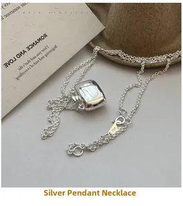 Macro detail of S925 sterling silver kettle pendant on a fine link chain necklace