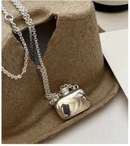 Close-up of polished S925 sterling silver flask pendant with elegant cable chain detail