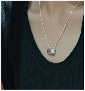 Detail of S925 sterling silver flask pendant necklace worn on black knitwear