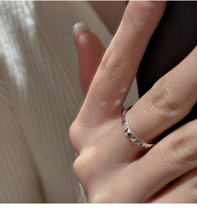 Macro shot of silver ring featuring geometric pyramid studs and punk style design