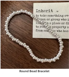 Detailed macro view of ribbed silver beaded elastic bracelet on a vintage wood surface