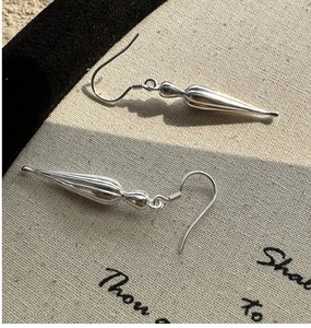 Detailed view of long teardrop S925 sterling silver earrings with a high-polished finish