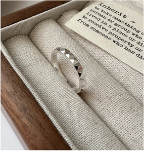Detail of S925 sterling silver ring with CNC carved geometric facets in a jewelry box