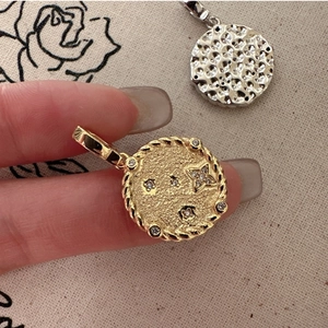 Detail of vintage round coin pendants with hammered texture and star zircon inlay