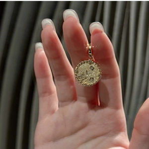 Detailed view of a textured gold sterling silver pendant featuring a celestial star pattern