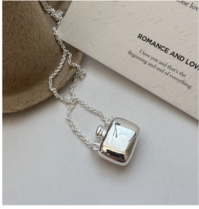 Detailed macro view of S925 silver perfume bottle pendant on fine O-chain necklace