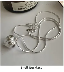 Macro detail of S925 sterling silver nut pod pendant on a matte snake bone chain
