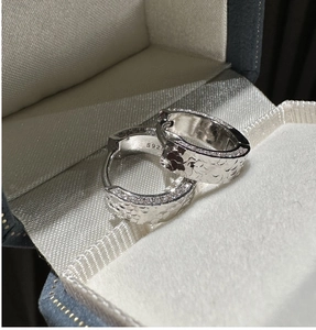Macro view of S925 sterling silver hoop earrings with hammered texture and pave zircon