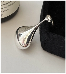 Macro shot of polished S925 sterling silver teardrop pendant with hallmark detail