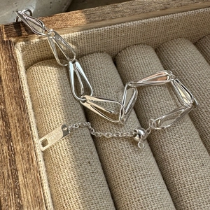 S925 sterling silver chain bracelet with elongated drop links on linen jewelry tray