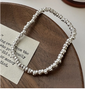 Macro detail of S925 sterling silver beaded bracelet with textured pumpkin-style beads