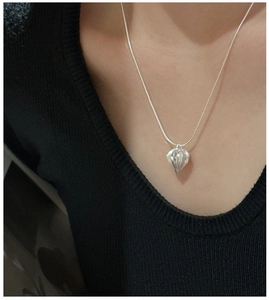 Detailed view of silver heart pendant with textured stripes on a sleek snake chain