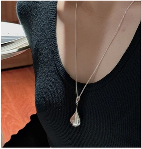 S925 sterling silver hollow teardrop pendant on model wearing V-neck black top