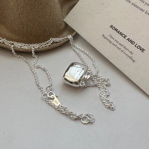 S925 sterling silver flask pendant necklace displayed on artistic paper and felt hat