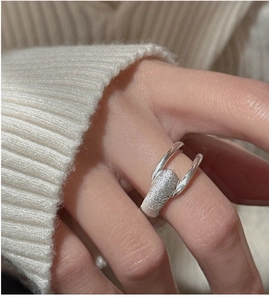 Detail of S925 sterling silver ring with textured metal band worn on finger