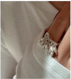 Close-up of S925 sterling silver ring featuring dangling white freshwater pearls