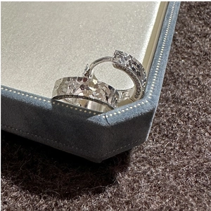 Macro shot of silver S925 sterling silver hoop earrings with textured hammered finish