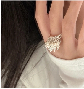 Detail of S925 silver beaded tassel ring on finger with white knit sleeve backdrop