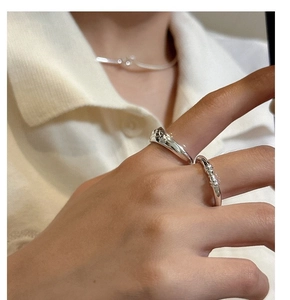 Detail of S925 sterling silver minimalist rings featuring a wide band and woven knot design