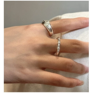Close-up of S925 sterling silver ring set featuring retro floral engraving and ribbed texture