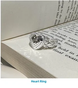 Detail of S925 silver heart ring with glitter texture on a hollow chain band