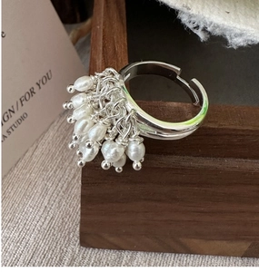 Macro detail of S925 silver beaded ring with natural pearl cluster on wooden frame