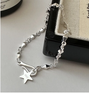 Détail du pendentif étoile en argent S925 et des maillons sur un écrin à bijoux