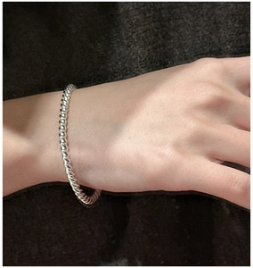 Detailansicht eines Armreifs aus 925er Sterlingsilber mit Kordeldesign am Handgelenk