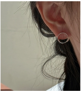 Minimalistische S925 Sterlingsilber Creolen an Model vor grauem Hintergrund getragen
