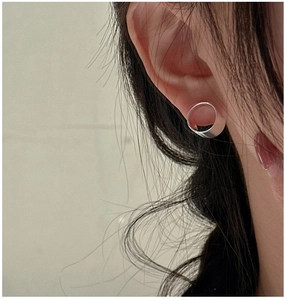 Nahaufnahme eines minimalistischen S925-Sterlingsilber-Ohrrings am Ohr des Models