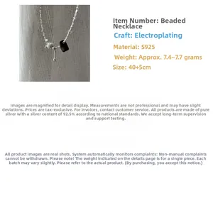 Macro shot of S925 sterling silver beaded necklace with shell pendant and metal drop detail