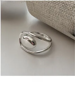 Detail of S925 sterling silver ring showing minimalist crossed bands and oval metal center